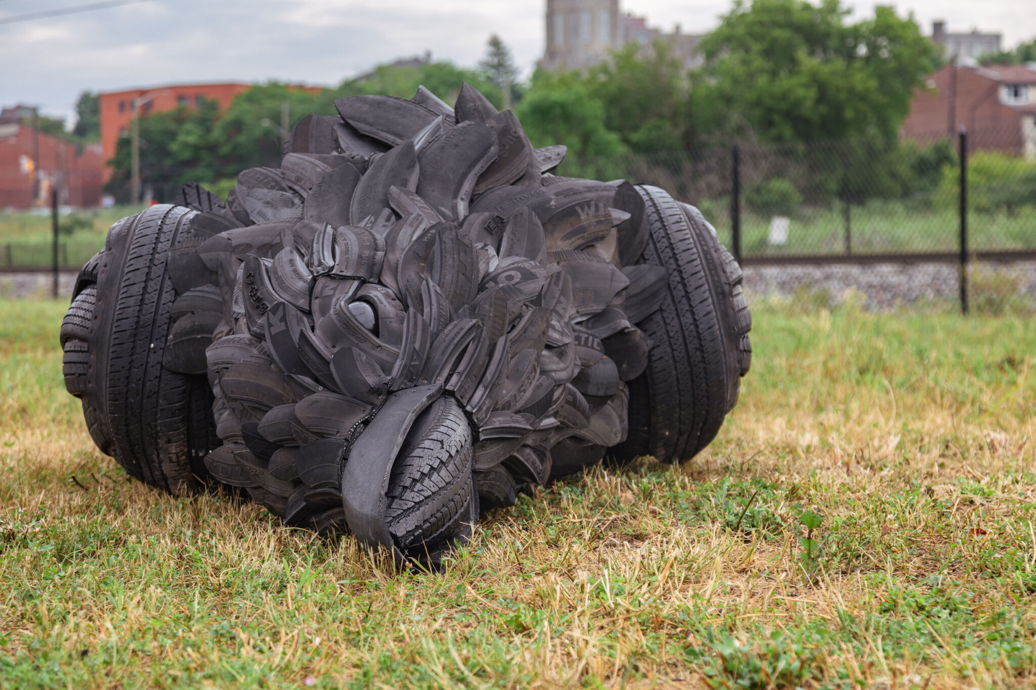 Plan rapproché de l’œuvre, mettant en évidence la tête du corbeau, composée de pneus recyclés.