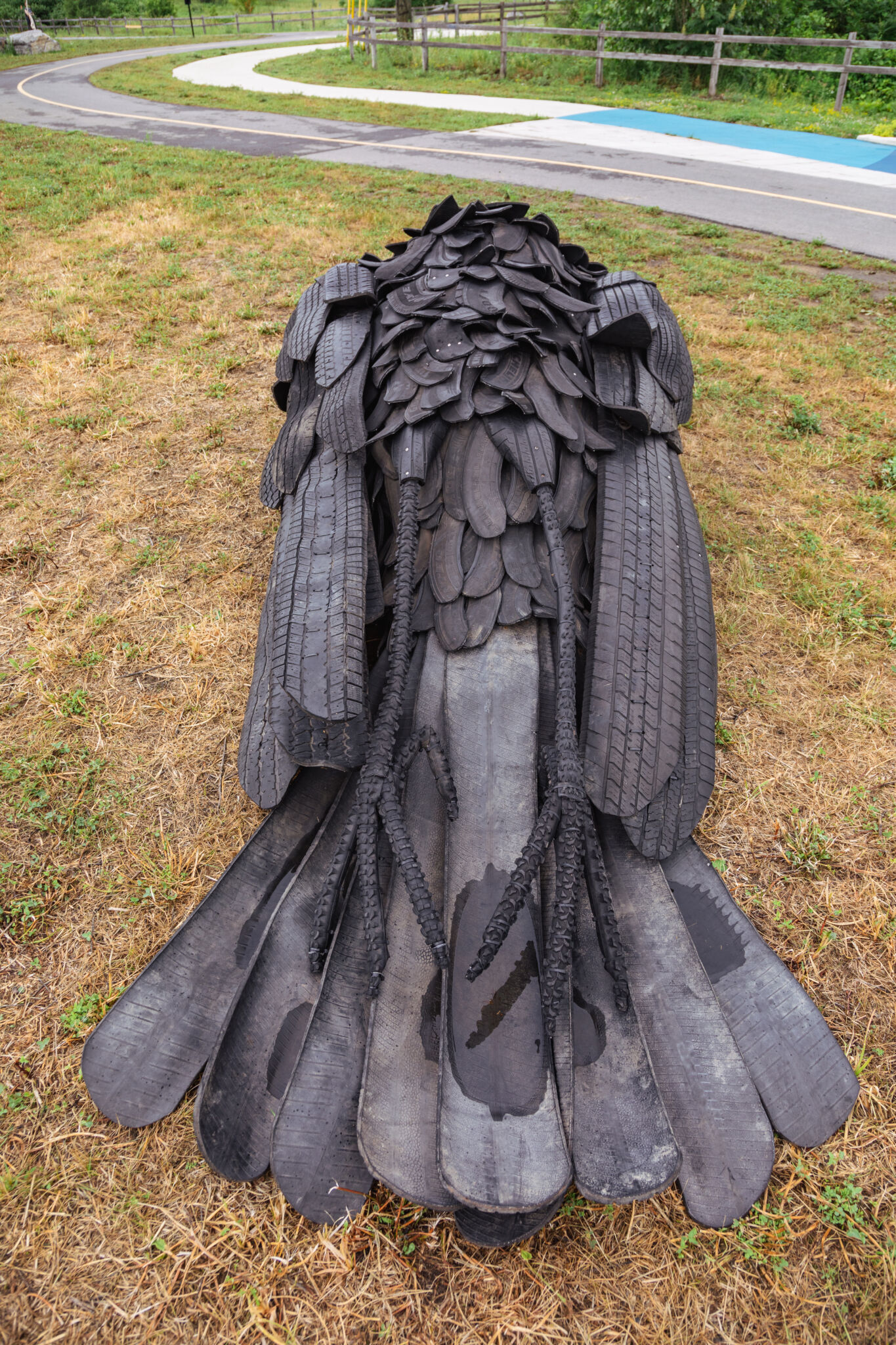 Plan rapproché de l’œuvre, mettant en évidence le corps du corbeau, composé de pneus recyclés.