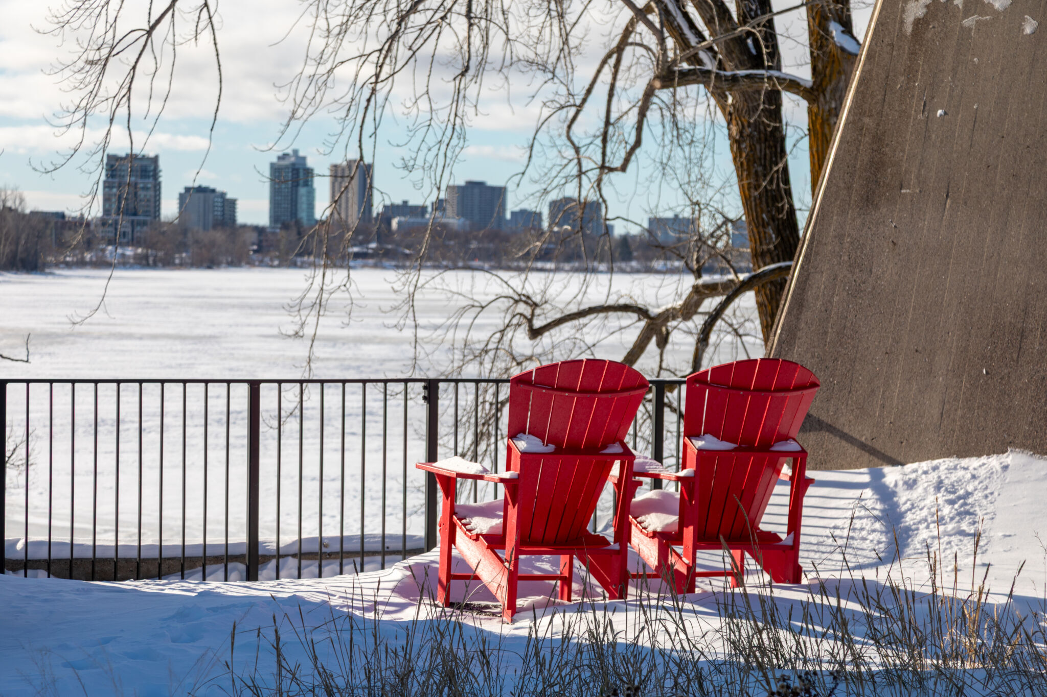 Red chairs along the Ottawa River in winter.