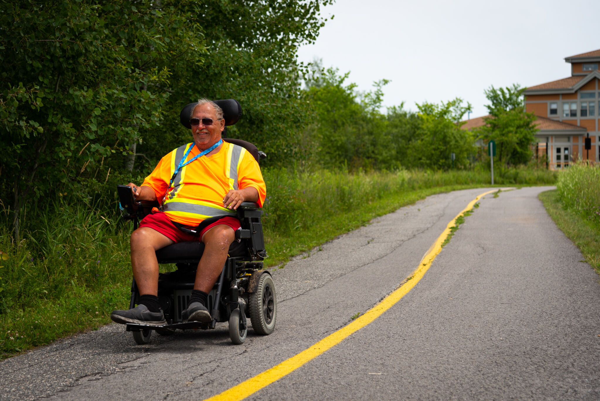 Person riding an assisted vehicle on a Gatineau Park pathway.