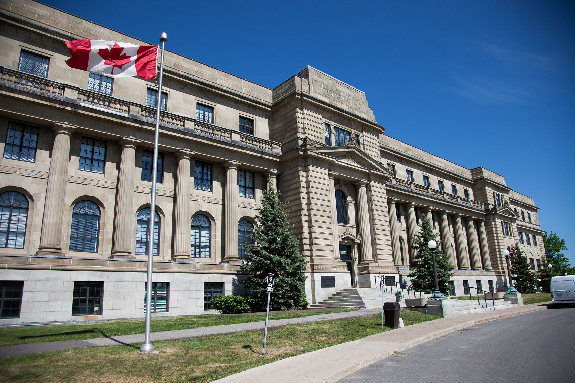 Le Conseil national de recherches Canada avec un drapeau du Canada en premier plan.