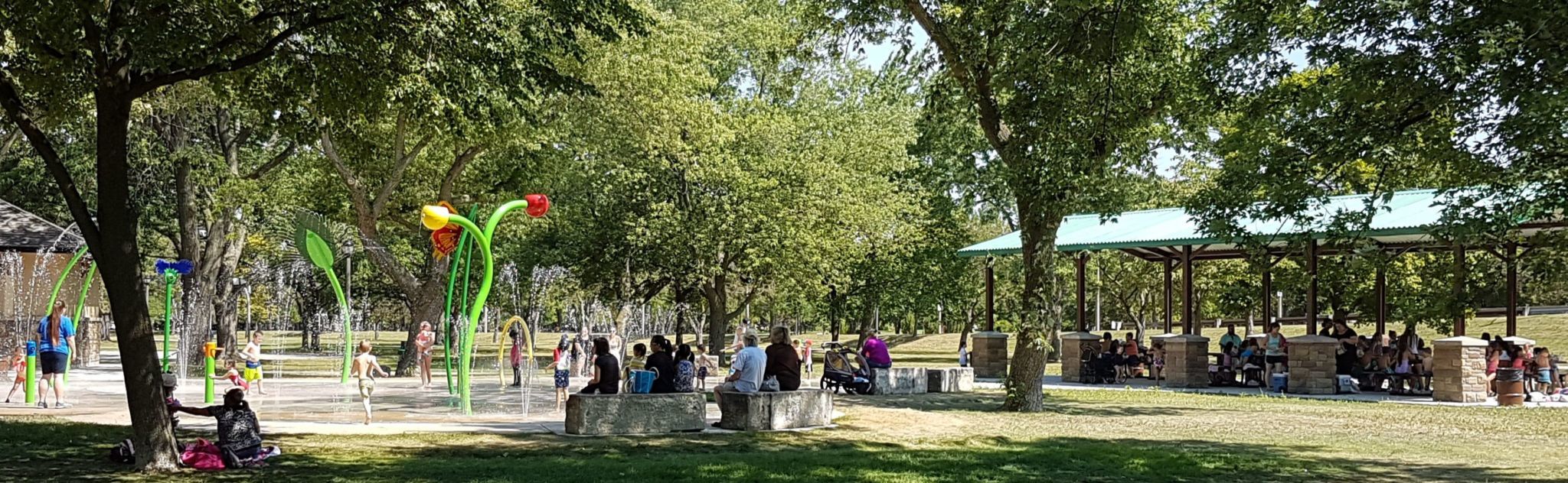 Un parc avec des arbres, des abris offrant de l'ombre et une aire de jeux d'eau, à Windsor. Source : Ressources naturelles Canada