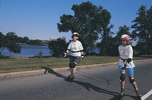 Personnes faisant du patin à roues alignées sur une promenade sans auto et fermée à la circulation automobile pendant les vélos-dimanches/vélos-weekends