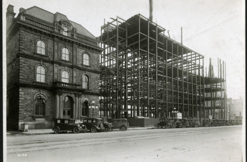 Construction de l’édifice de la Confédération, vue de la rue Wellington en direction nord est. 4 mai 1929. Archives de la Commission du district fédéral. Source : Bibliothèque et Archives Canada (e999908718-u)