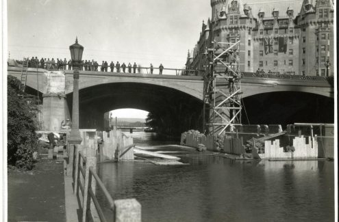 Des badauds observent l’élargissement du pont Plaza, et à l’arrière-plan, le Château Laurier. 25 août 1938. Source : Bibliothèque et Archives Canada (e999909164-u)