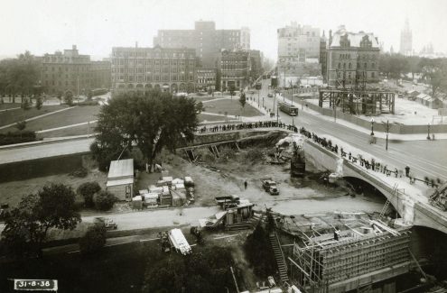 View of Connaught Place construction site and widening of the Plaza Bridge arch, with Elgin and Wellington streets in the background. August 31, 1938. Credit: Library and Archives Canada / E999909167-u