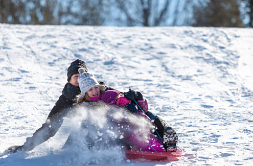 Adult and child tobogganing