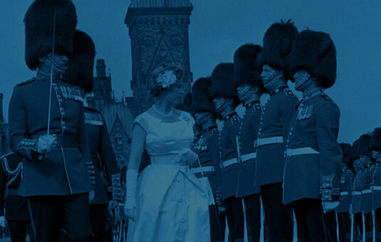 Historic picture of the Queen receiving a guard of honour in front of the Canadian Parliament.
