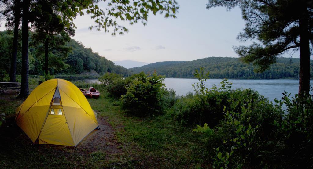 Une tente jaune sur le bord du lac.