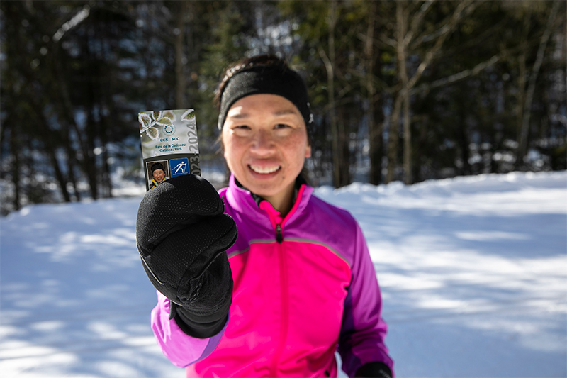 Une skieur du parc de la Gatineau montre sa laissez-passer d'hiver 2023-2024.