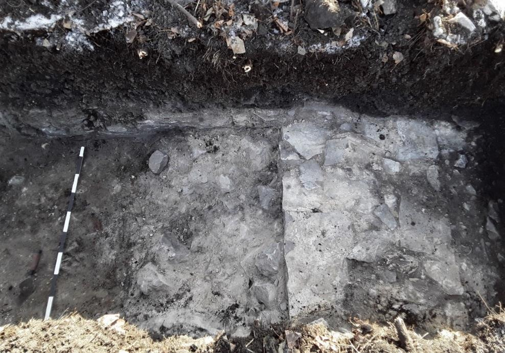 Une fosse creusée mécaniquement expose une partie de la fondation en calcaire.