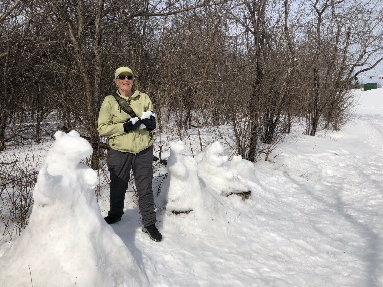 Maggie Glossop sculpting three snow bears along the Kichi Sibi Winter Trail