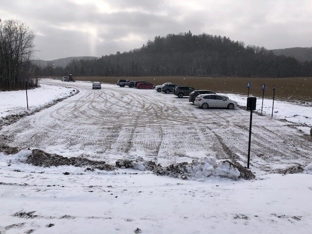 P15 parking lot with snow and parked cars.