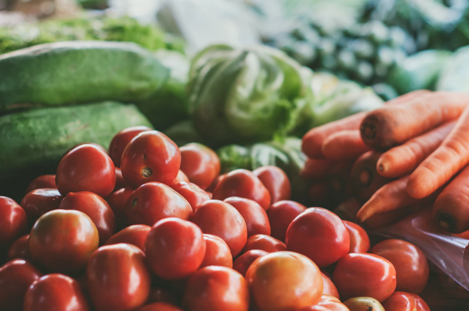 Plan rapproché d’un étal de tomates, carottes et divers légumes verts